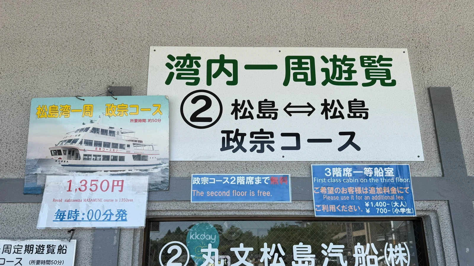 「湾内一周遊覧 政宗コース」と書かれた丸文松島汽船の乗船窓口の看板