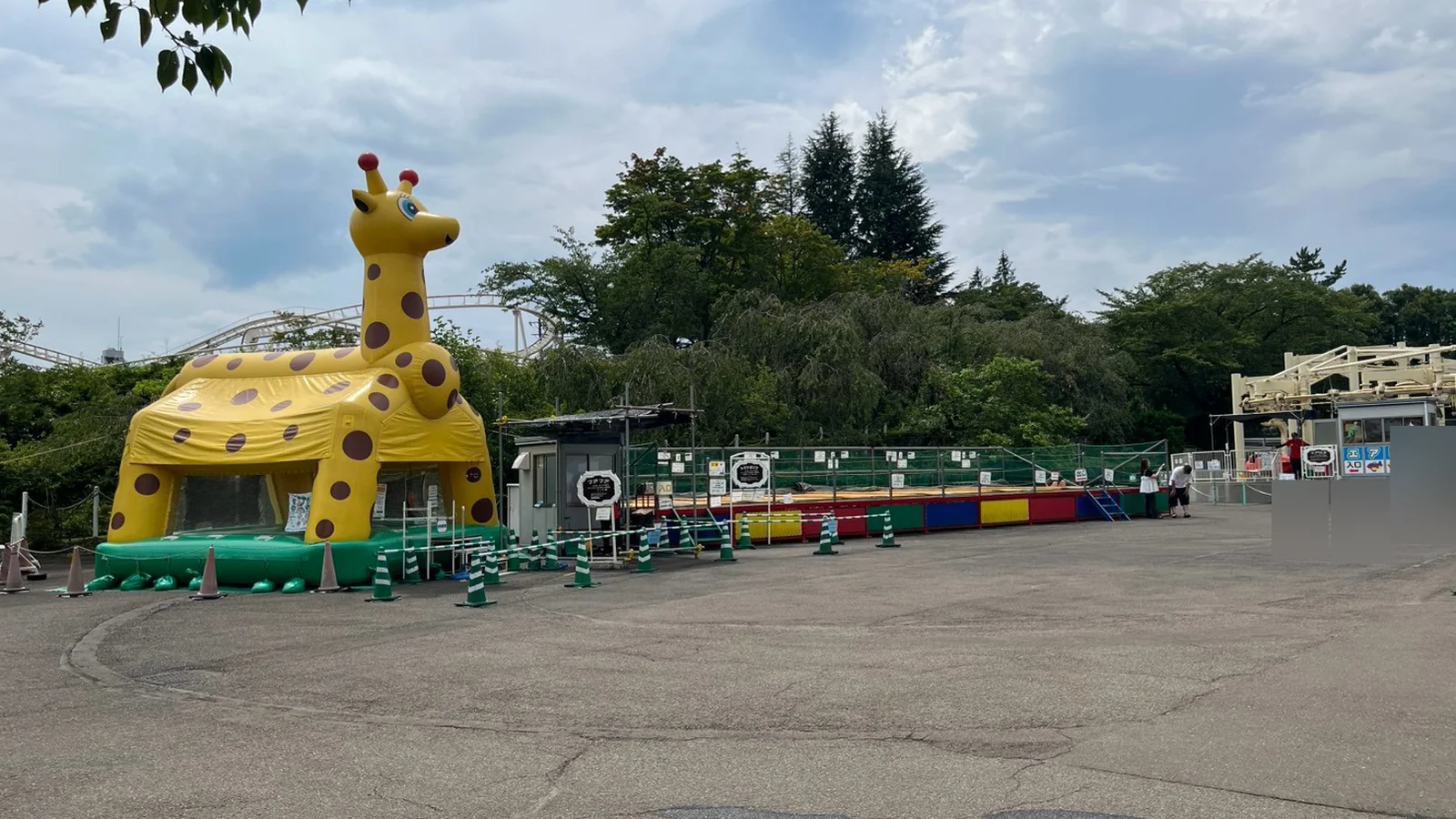 キリンの形をしたエアートランポリン型の遊具フアフアと、その横のバッテリーカー乗り場